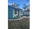 Side view of teal house with a walkway and landscaping at 3407 Avenue J Nw, Winter Haven, FL 33881