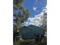Back of teal house with a tree and chain link fence at 3407 Avenue J Nw, Winter Haven, FL 33881