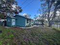 View of teal house from the side yard, showing a spacious area at 3407 Avenue J Nw, Winter Haven, FL 33881