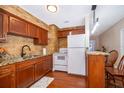 Renovated kitchen, wood cabinets, granite counters, and white appliances at 7709 Ravenna Ave, Orlando, FL 32819