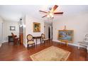 Bright living room with hardwood floors, a ceiling fan, and large artwork at 7709 Ravenna Ave, Orlando, FL 32819