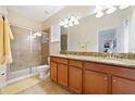 Primary bathroom with double sinks, granite countertop and shower at 8958 Sugar Palm Rd, Kissimmee, FL 34747