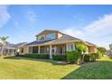 Back of house with screened lanai, lush landscaping, and a large yard at 1280 Osprey Landing Dr, Lakeland, FL 33813
