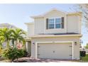 Two-story house with light beige siding, a two-car garage, and landscaping at 3112 Armstrong Spring Dr, Kissimmee, FL 34744