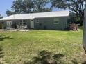 Gray house with patio, backyard and trees at 4040 Ne 95Th Rd, Wildwood, FL 34785