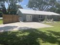 Gray house with patio, concrete driveway and backyard at 4040 Ne 95Th Rd, Wildwood, FL 34785