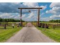 Long driveway entrance with wooden gate and star compass at 6225, 6229 Deen Still Rd, Lakeland, FL 33809