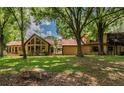 Back exterior of home showcasing landscaping and a deck at 6225, 6229 Deen Still Rd, Lakeland, FL 33809