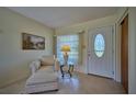 Bright and airy living room with a comfy armchair and entryway at 4331 Valencia Dr, Indian Lake Estates, FL 33855