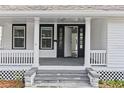 Inviting front porch with white columns and a black door at 405 S Ridgewood Ave, Daytona Beach, FL 32114