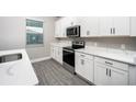 Modern kitchen with white cabinets and quartz countertops at 3327 Chinotto Dr, Lake Alfred, FL 33850