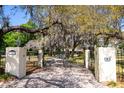 Private gated entrance to property with lush landscaping at 8723 A D Mims Rd, Orlando, FL 32818