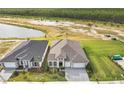 Aerial view of two houses on a tree-lined street next to a lake at 389 Mosaic Blvd, Daytona Beach, FL 32124