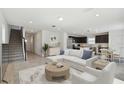 Open living room with L-shaped sectional sofa, coffee table, and stairs leading to the second floor at 468 Waterford Dr, Lake Alfred, FL 33850