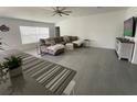 Bright living room with tile floors, sectional sofa, and large TV at 6945 Church Lake St, Groveland, FL 34736