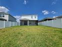 Large backyard with a screened patio and grassy area at 1564 Eucalyptus Way, Davenport, FL 33837