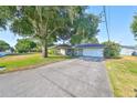Single-story house with a large tree, driveway, and attached garage at 220 Coleman E Dr, Winter Haven, FL 33884