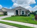 One-story home with a two-car garage and landscaped lawn at 7771 Lake James Blvd, Lakeland, FL 33810