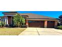 Beautiful one-story home with three car garage and lush landscaping at 5446 Pebble Beach Dr, Lakeland, FL 33812