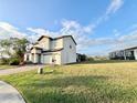 Two story house with light beige walls, brown roof, and a two car garage at 210 Kenny Blvd, Haines City, FL 33844