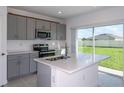 Modern kitchen with stainless steel appliances and sliding door access to backyard at 2647 Fernleaf St, Auburndale, FL 33823