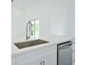 White kitchen with stainless steel sink and dishwasher at 7811 Red Grange Blvd, Indian Lake Estates, FL 33855