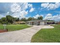 Gray house with a red door and a spacious driveway at 1075 8Th Nw St, Winter Haven, FL 33881