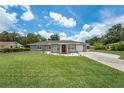 Ranch style home with a red door and lush lawn at 1075 8Th Nw St, Winter Haven, FL 33881