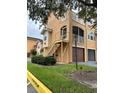 Side view of the condo building with a private staircase and garage at 12031 Villanova Dr # 110, Orlando, FL 32837