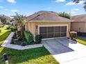 House exterior with a screened garage and landscaped yard at 7067 Sw 91St Ct, Ocala, FL 34481