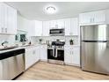 Modern kitchen with white cabinets and stainless steel appliances at 241 Menlo Park Ave, Davenport, FL 33897