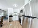 Modern kitchen with white cabinets and stainless steel appliances at 241 Menlo Park Ave, Davenport, FL 33897