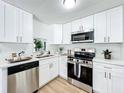 Modern kitchen with white cabinets and stainless steel appliances at 241 Menlo Park Ave, Davenport, FL 33897