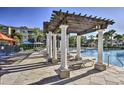 Relaxing pool area with pergola, lounge chairs, and umbrellas at 7663 Sir Kaufmann Ct, Kissimmee, FL 34747