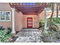 Red front door entry with pergola and white columns at 8901 Nw 136Th Avenue Rd, Ocala, FL 34482