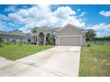 Tan one-story house with a three-car garage and manicured lawn at 4046 Dinner Lake Way, Lake Wales, FL 33859