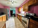 Kitchen with stainless steel appliances, wooden cabinets, and tile flooring at 6004 Hilltop E Ln, Lakeland, FL 33809