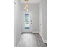 Bright entryway with gray tile floors and a stylish light fixture at 1126 Whitewater Bay Dr, Groveland, FL 34736