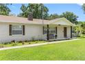 Front view of a renovated brick home featuring a porch and landscaping at 4314 Ridge Rd, Lakeland, FL 33811