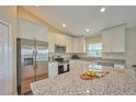 Spacious kitchen with stainless steel appliances and granite countertops at 7031 Red Grange Boulevard Ave, Indian Lake Estates, FL 33855