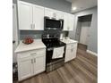 Modern kitchen with white cabinets and stainless steel appliances at 718 Saratoga Ave, Lakeland, FL 33815