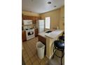 Kitchen with white appliances and breakfast bar at 4000 Santa Maria Dr # 108, Kissimmee, FL 34741