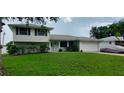 Two-story house with a spacious lawn and attached garage at 555 Alachua Dr, Winter Haven, FL 33884
