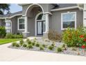 Gray house with white columns, arched entryway, and landscaped yard at 8796 Sw 196Th Terrace Rd, Dunnellon, FL 34432