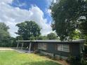 Dark-colored ranch house with mature trees and a well-maintained lawn at 118 5Th Jpv St, Winter Haven, FL 33880