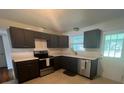 Modern kitchen with dark cabinets and stainless steel appliances at 1546 Daytona Ave, Daytona Beach, FL 32117