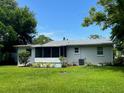 Spacious backyard with green grass and screened porch at 1546 Daytona Ave, Daytona Beach, FL 32117