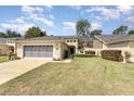 Front view of a single-story house with a three-car garage and a screened patio at 15695 Sw 13Th Cir, Ocala, FL 34473