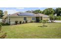 Single-story house with solar panels, well-maintained lawn, and a landscaped front yard at 105 Hainesport Dr, Lake Alfred, FL 33850