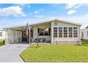 Exterior view of a manufactured home with a covered carport and landscaped lawn at 6505 Raintree Ne Ln, Winter Haven, FL 33881